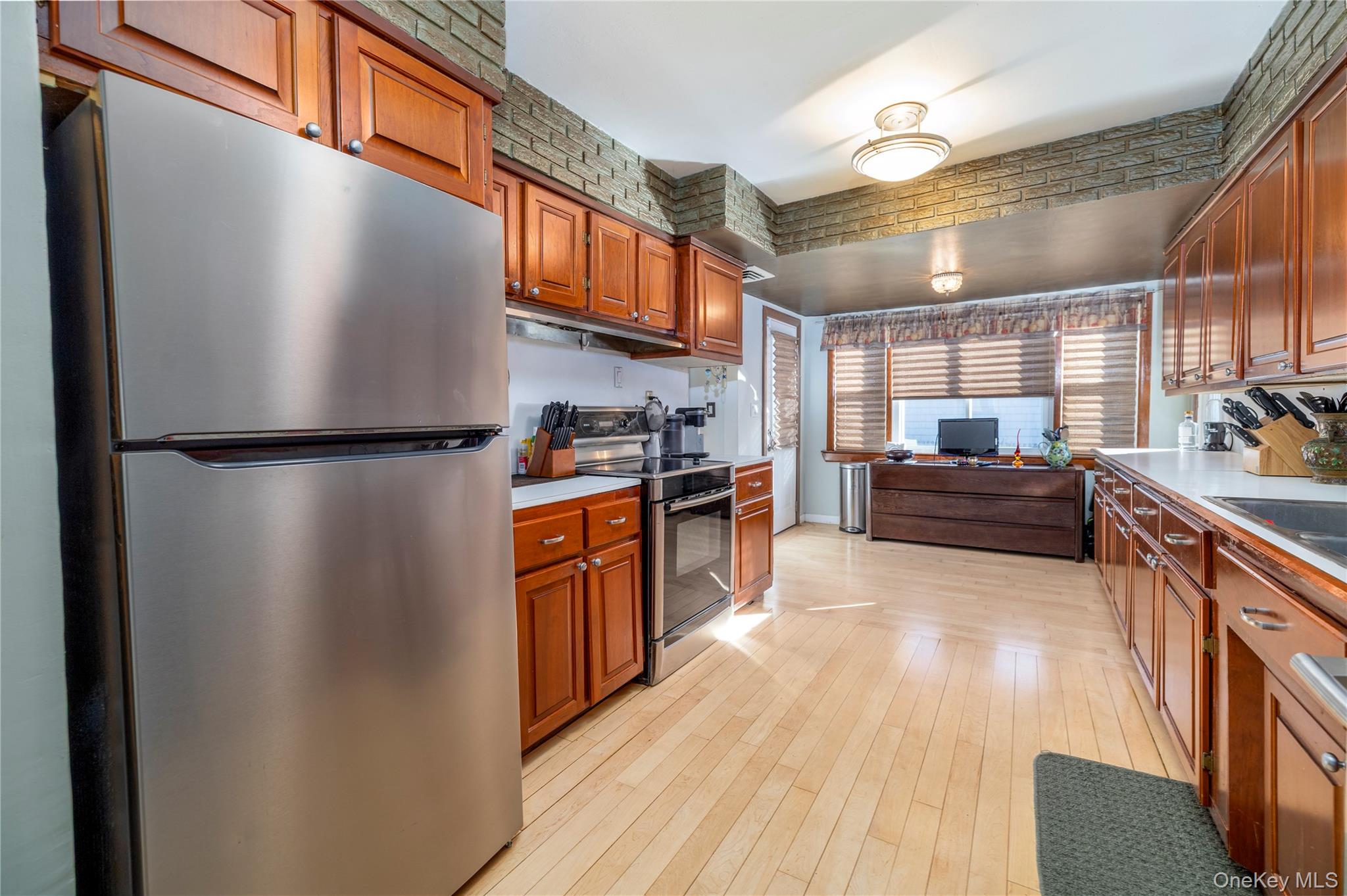 136 Greenway Road Lido Beach, NY 11561 - Photo 7 of 29 a kitchen with stainless steel appliances granite countertop a refrigerator a stove a sink and a microwave