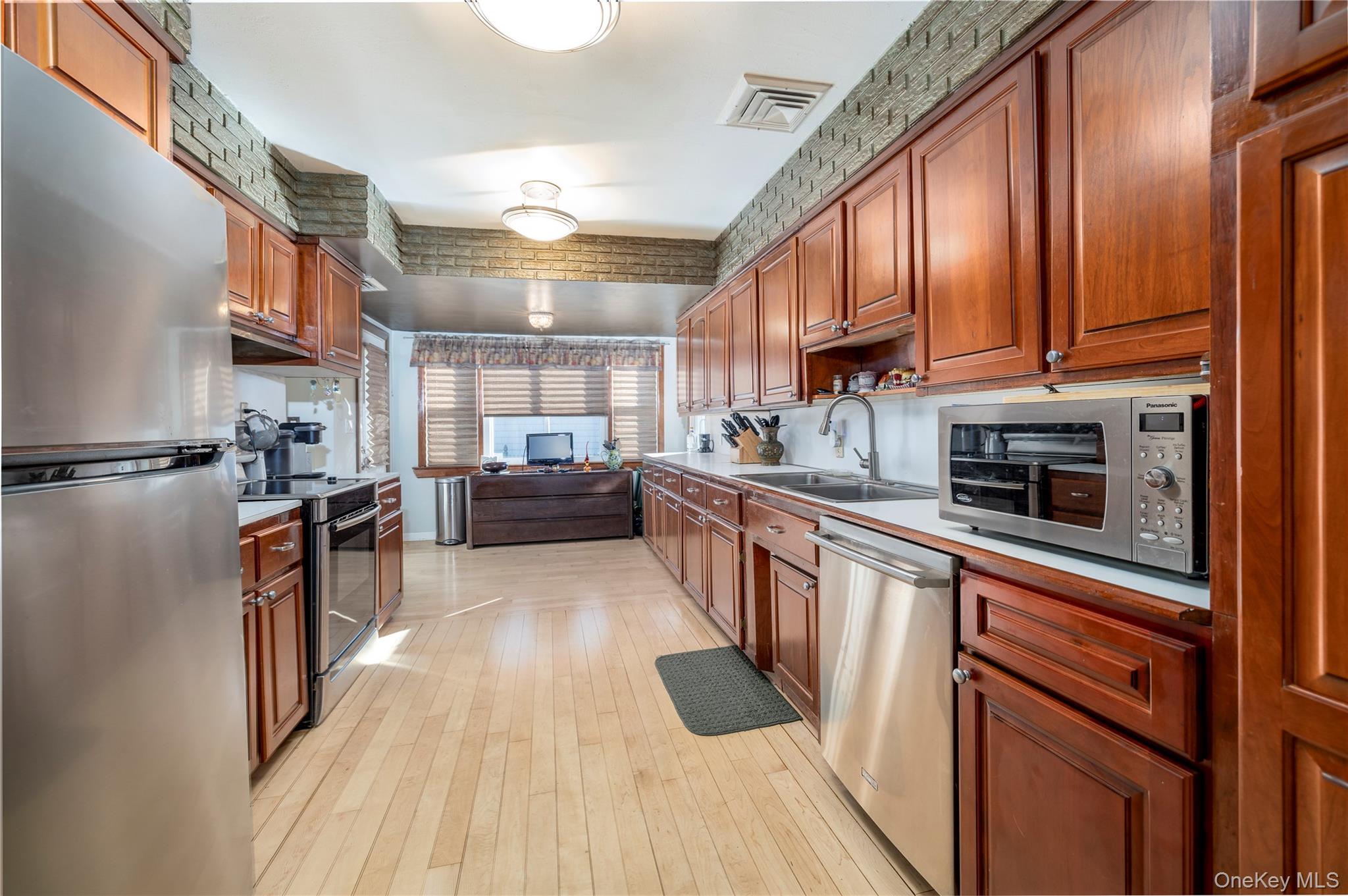 136 Greenway Road Lido Beach, NY 11561 - Photo 8 of 29 a kitchen with stainless steel appliances granite countertop wooden cabinets a stove top oven a sink and dishwasher