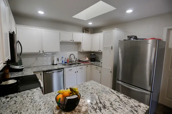 a kitchen with stainless steel appliances granite countertop a refrigerator sink and cabinets