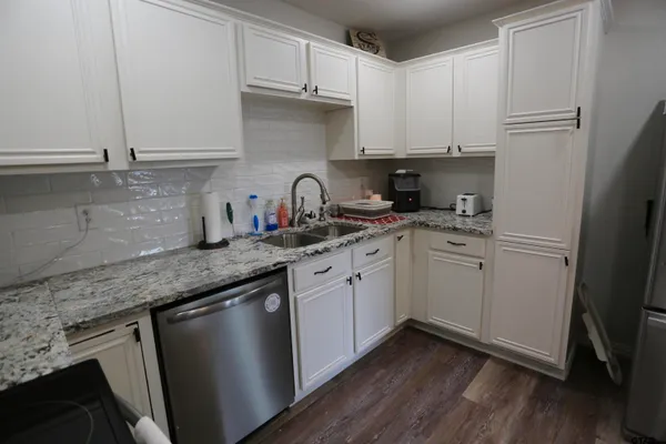 a kitchen with stainless steel appliances granite countertop a sink a stove a refrigerator and cabinets