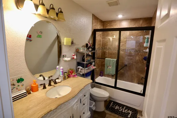 a bathroom with a sink vanity mirror and toilet
