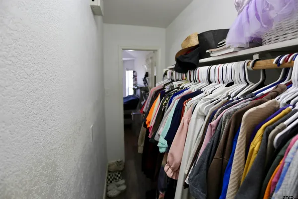 a view of walk in closet with clothes and shoes