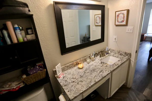 a bathroom with a granite countertop sink and a mirror