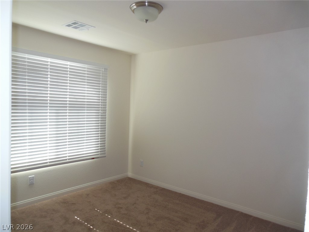 6390 Jackson Spring Road Las Vegas, NV 89118 - Photo 12 of 27 A well-lit room awaits your personal touch, featuring soft carpet flooring and a ceiling-mounted light fixture.