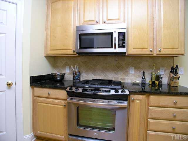 7413 Fontana Ridge Lane Raleigh, NC 27613 - Photo 11 of 25 Gas stove and new oven compliment the stunning counter tops.