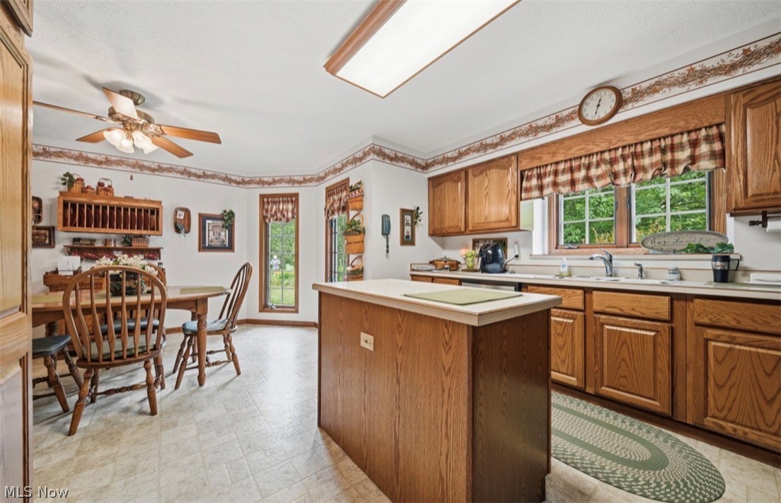 3556 Lake Road Conneaut, OH 44030 - Photo 12 of 39 Eat-in kitchen featuring wood cabinetry, a central island with a solid surface countertop, and ample natural light from multiple windows