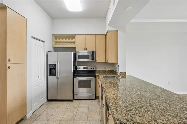 a kitchen with stainless steel appliances granite countertop a refrigerator and a stove top oven