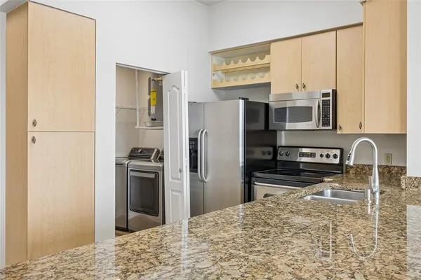 a kitchen with stainless steel appliances granite countertop a refrigerator and a stove top oven