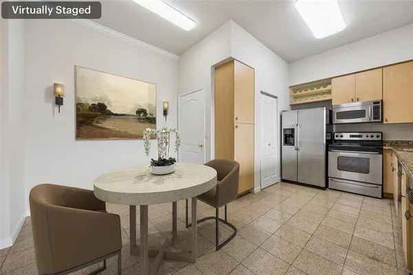 a kitchen with stainless steel appliances a sink a microwave a refrigerator and chairs