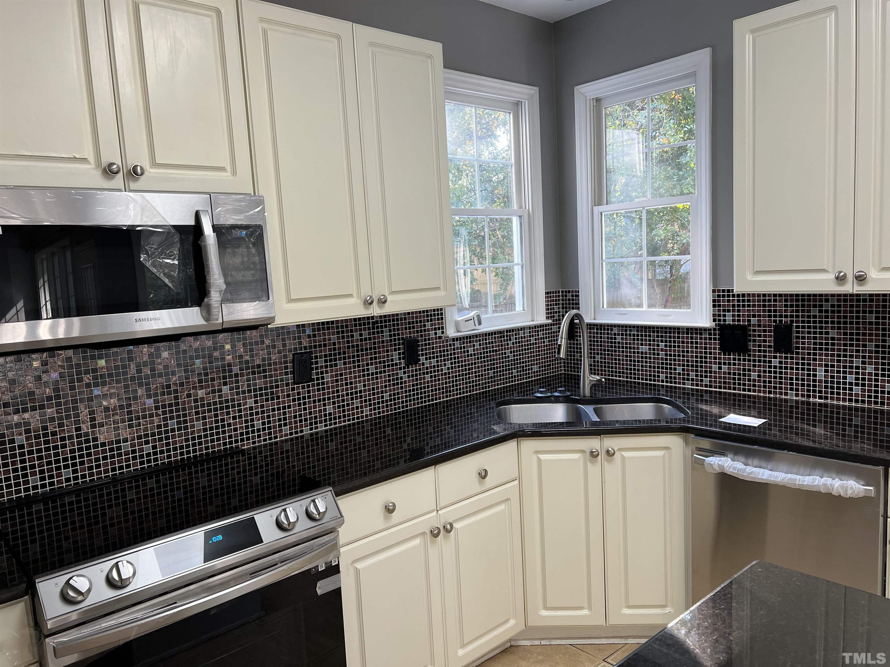 5113 Six Point Trail Raleigh, NC 27616 - Photo 29 of 53 a kitchen with granite countertop white cabinets and black appliances
