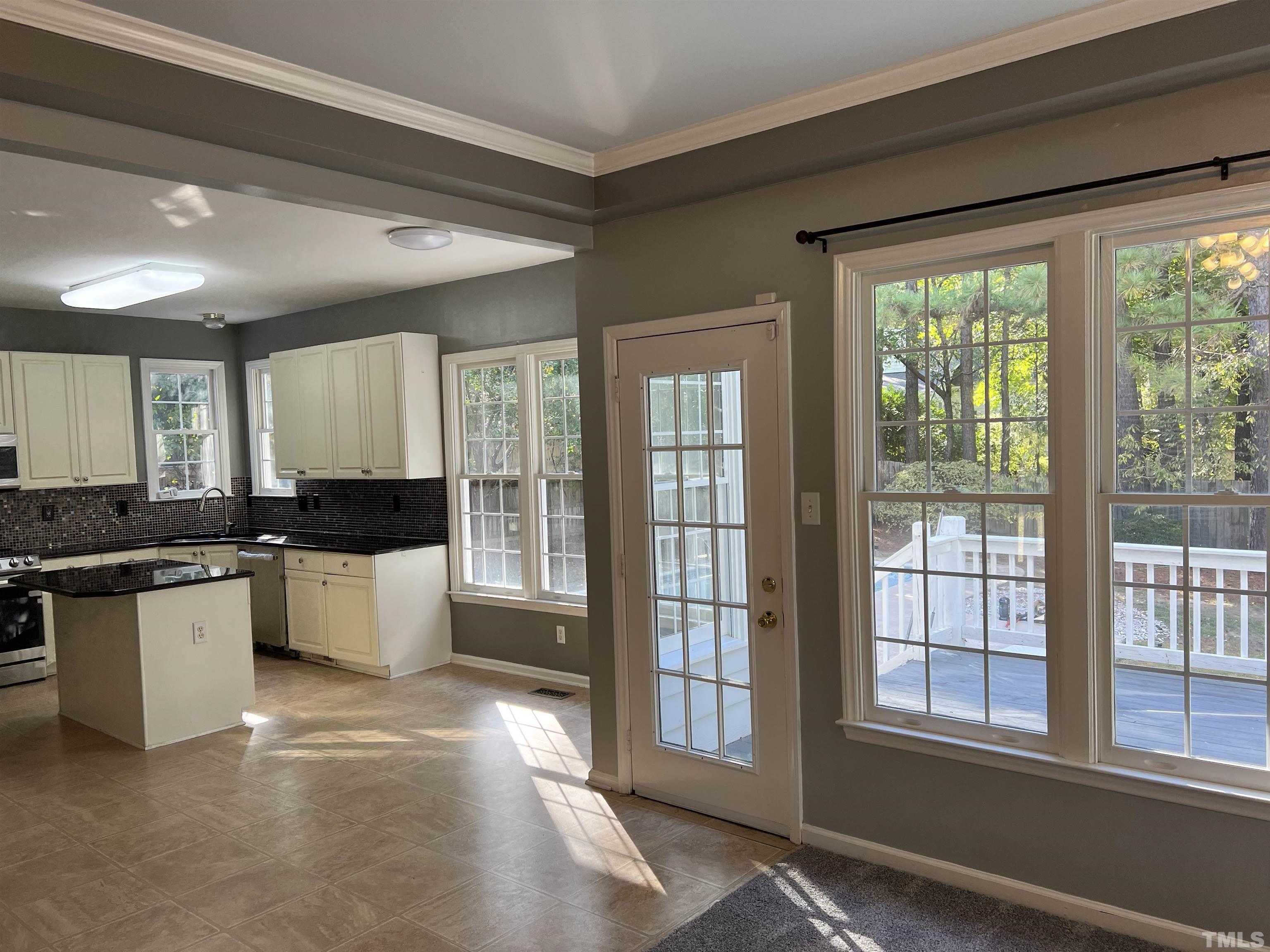 5113 Six Point Trail Raleigh, NC 27616 - Photo 46 of 53 a large white kitchen with kitchen island a large window a sink and a counter