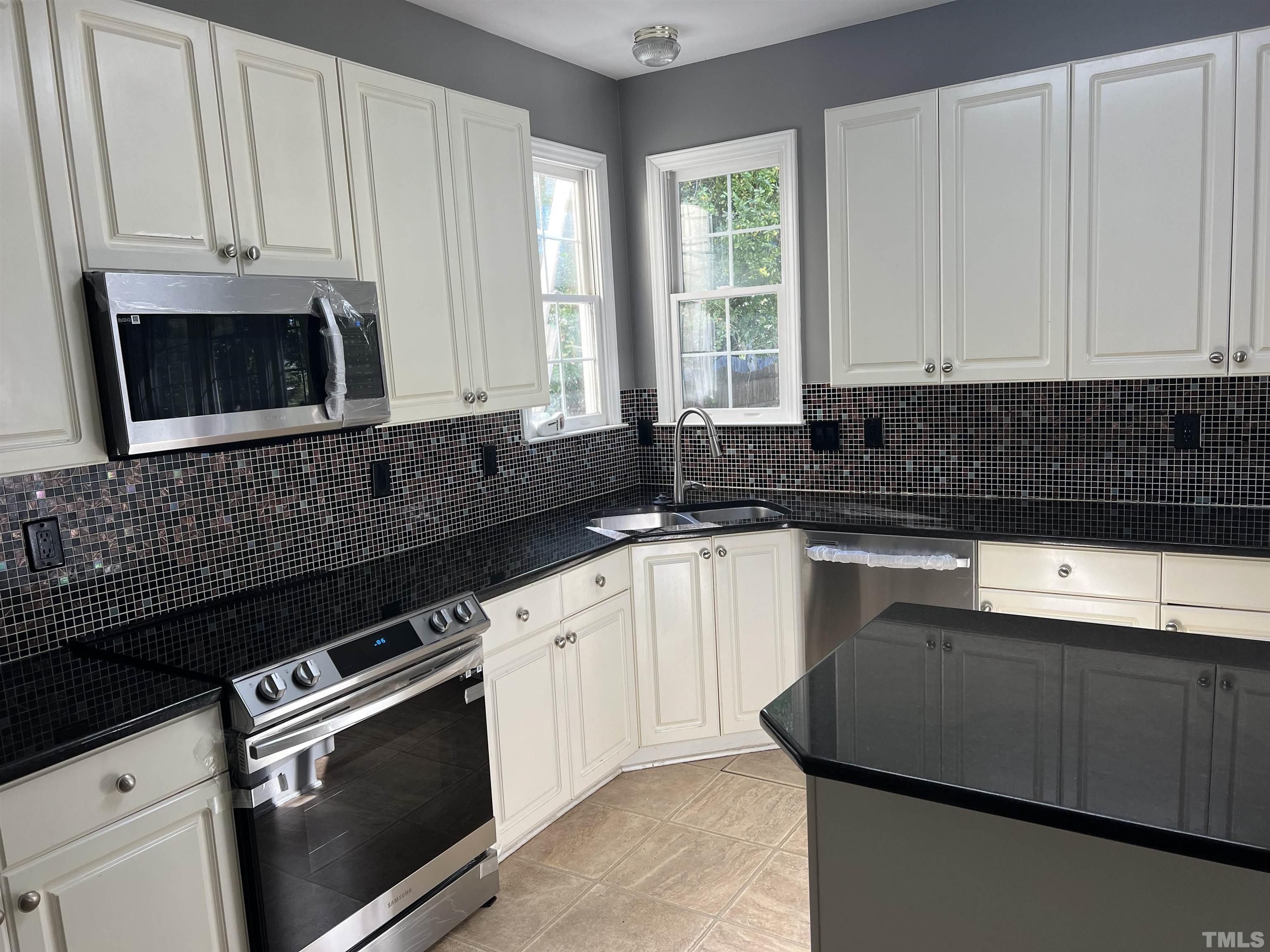 5113 Six Point Trail Raleigh, NC 27616 - Photo 8 of 53 a kitchen with granite countertop white cabinets and black appliances