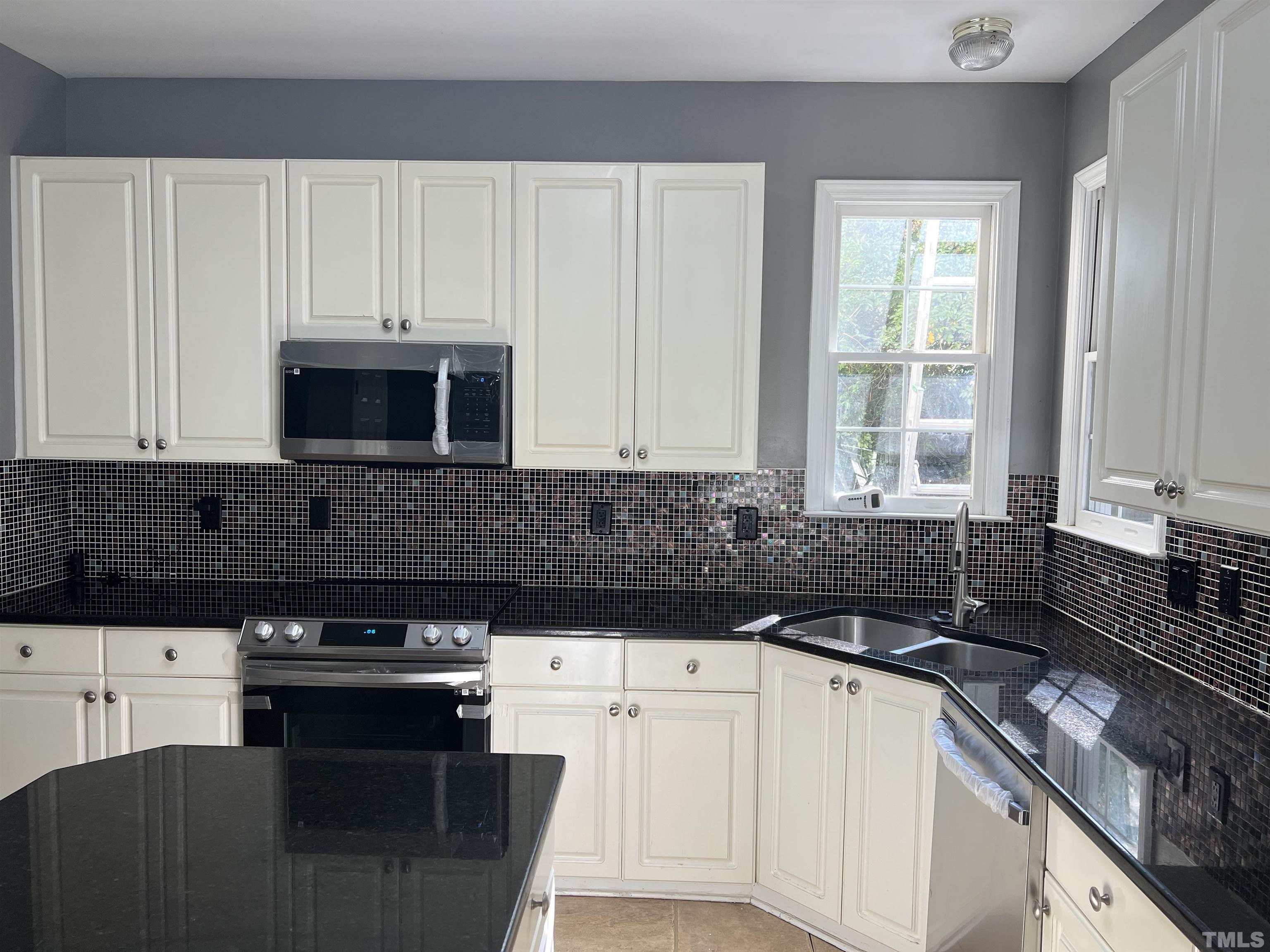 5113 Six Point Trail Raleigh, NC 27616 - Photo 9 of 53 a kitchen with granite countertop a sink a stove and cabinets