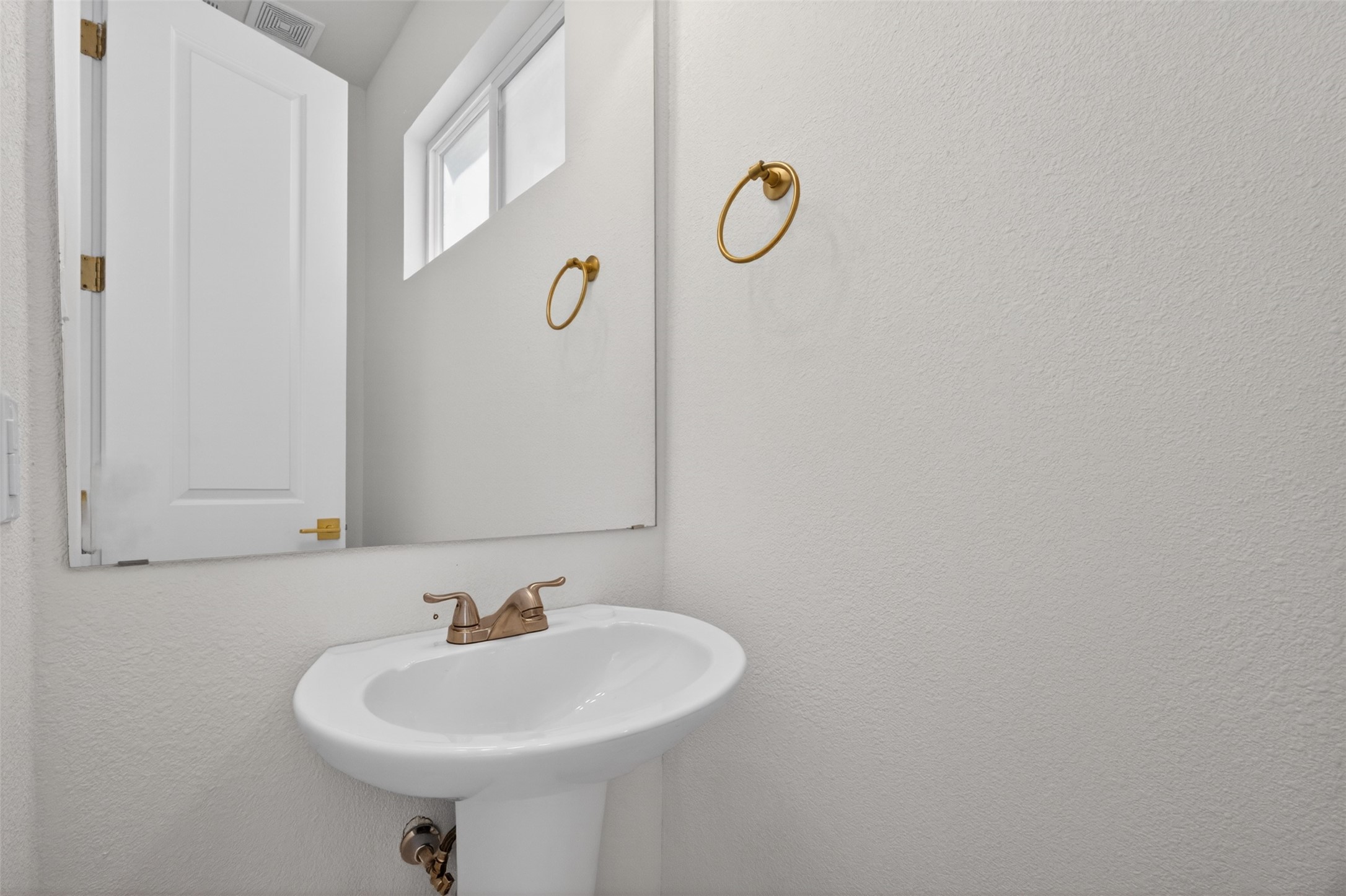 5906 St Augustine Street, Unit F Houston, TX 77021 - Photo 13 of 34 Powder-room vanity with a pedestal sink, window, and gold-tone fixtures.