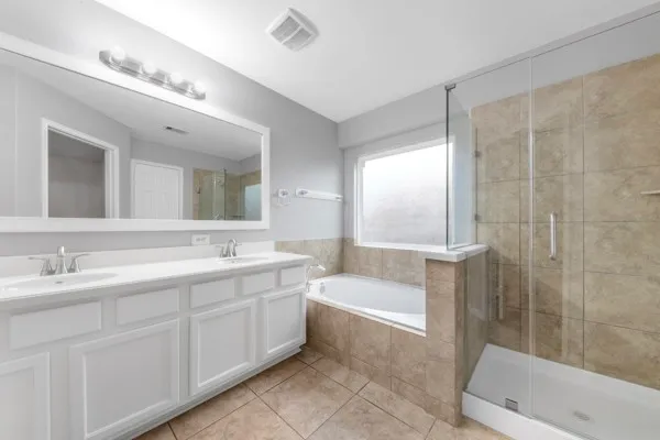 a bathroom with a tub a sink and mirror