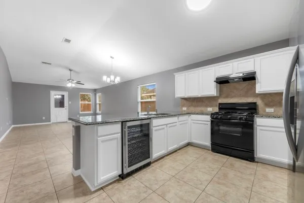 a kitchen with granite countertop a stove and a refrigerator
