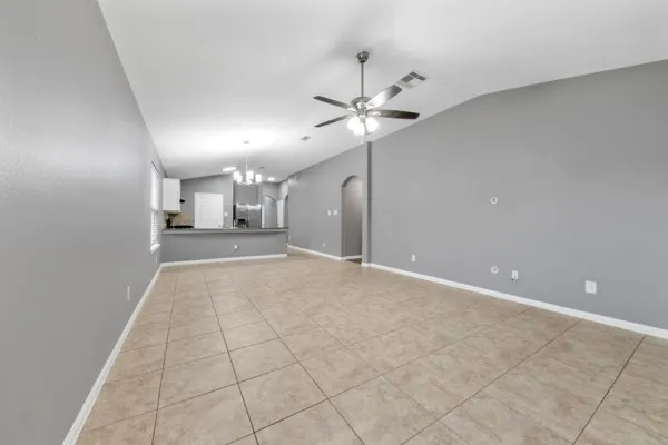 a view of a big room with windows and chandelier fan