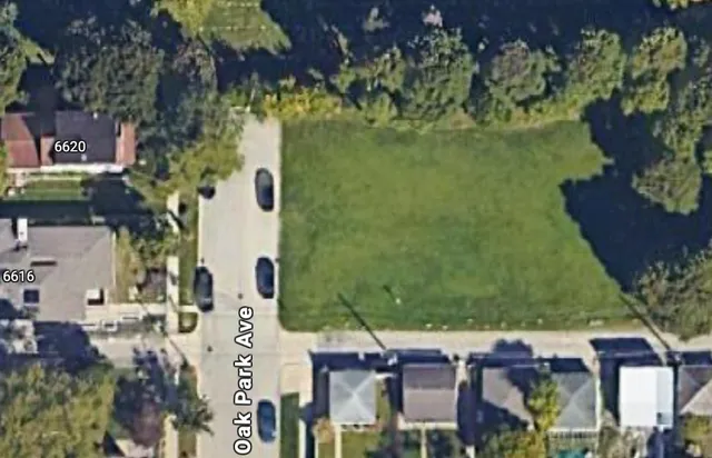 an aerial view of a residential houses with outdoor space and street view