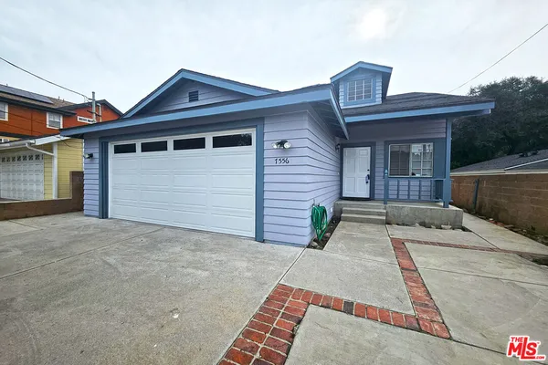 a front view of a house with a garden and yard