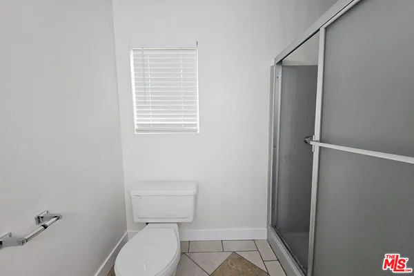 a white toilet sitting next to a shower