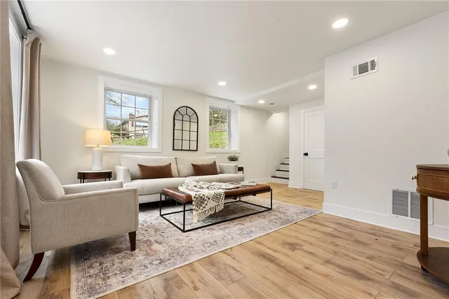 a dining room with wooden floor a chandelier a wooden table and chairs