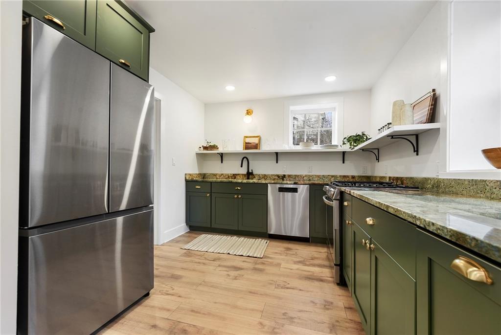 4978 South Pioneer Road Gibsonia, PA 15044 - Photo 20 of 49 a kitchen with stainless steel appliances granite countertop a refrigerator a sink dishwasher a stove with cabinets and wooden floor