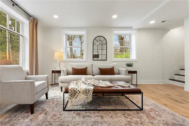 a living room with furniture a rug and a window