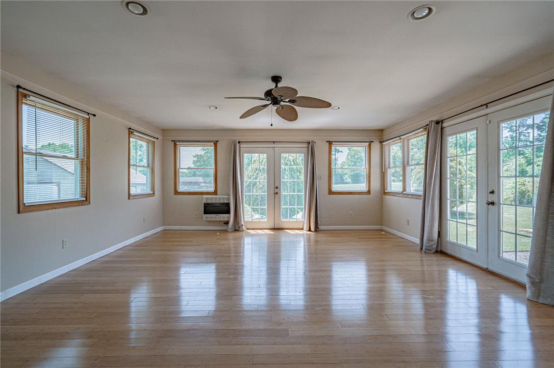 652 Old State Road Oley, PA 19547 - Photo 25 of 54 Sun-drenched interiors flow onto a vibrant outdoor space through elegant French doors, complete with a cooling ceiling fan.