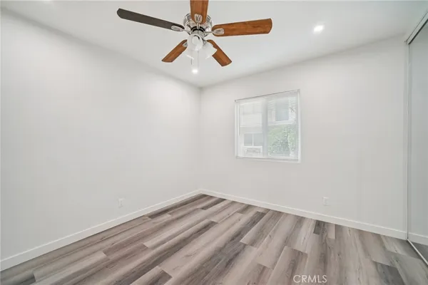 an empty room with a window and a ceiling fan