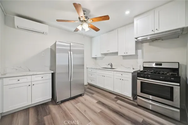 a kitchen with stainless steel appliances a stove a sink and a refrigerator