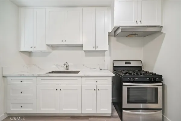 a kitchen with granite countertop white cabinets and stainless steel appliances