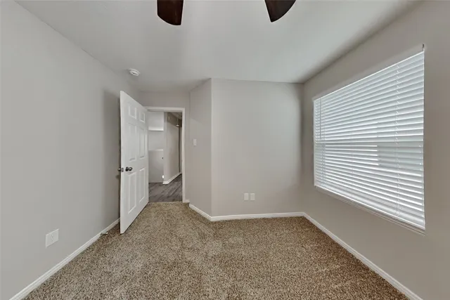 a view of an empty room with window and closet