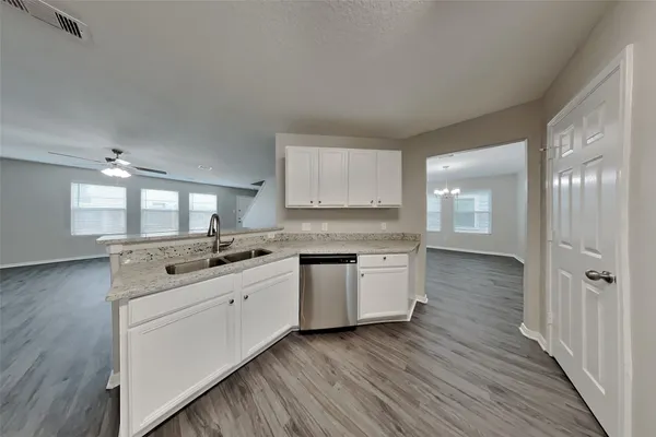a kitchen with a sink stove and wooden floor