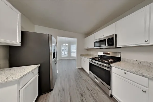 a kitchen with stainless steel appliances a stove microwave and cabinets