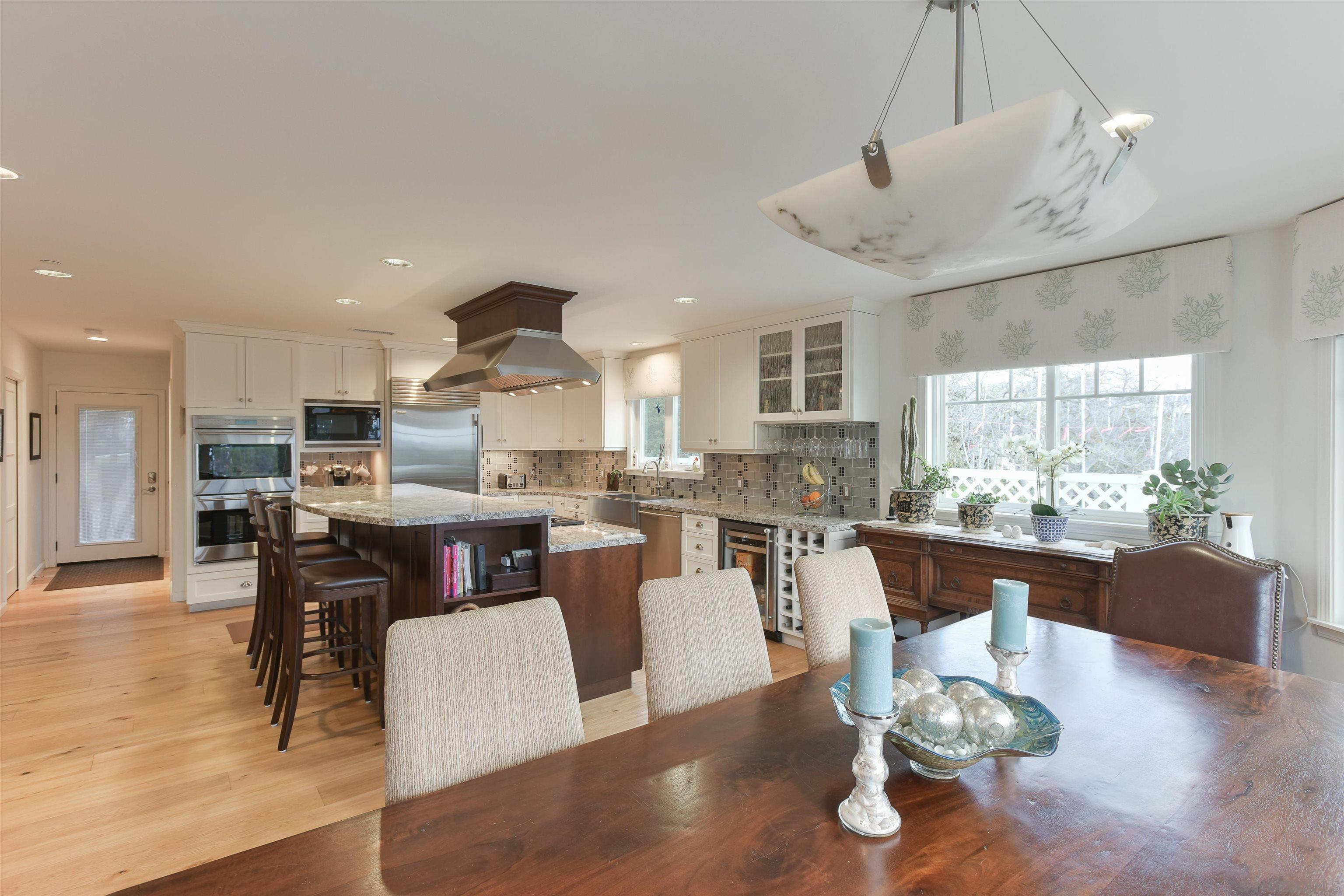 222 Barbara Avenue Solana Beach, CA 92075 - Photo 11 of 37 a dining room with wooden floor a chandelier a glass table and chairs