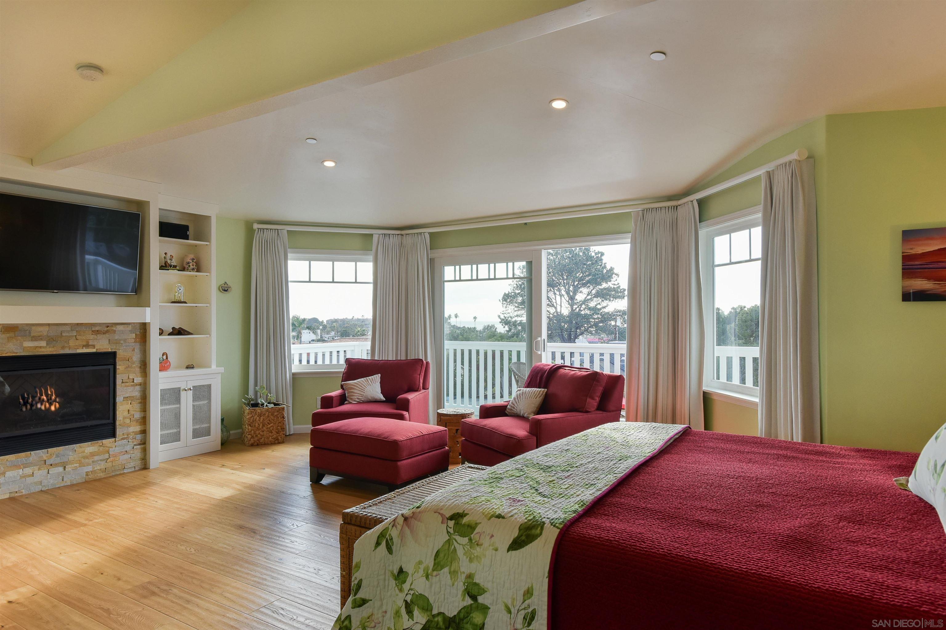 222 Barbara Avenue Solana Beach, CA 92075 - Photo 13 of 37 a bedroom with a balcony a bed and a fireplace
