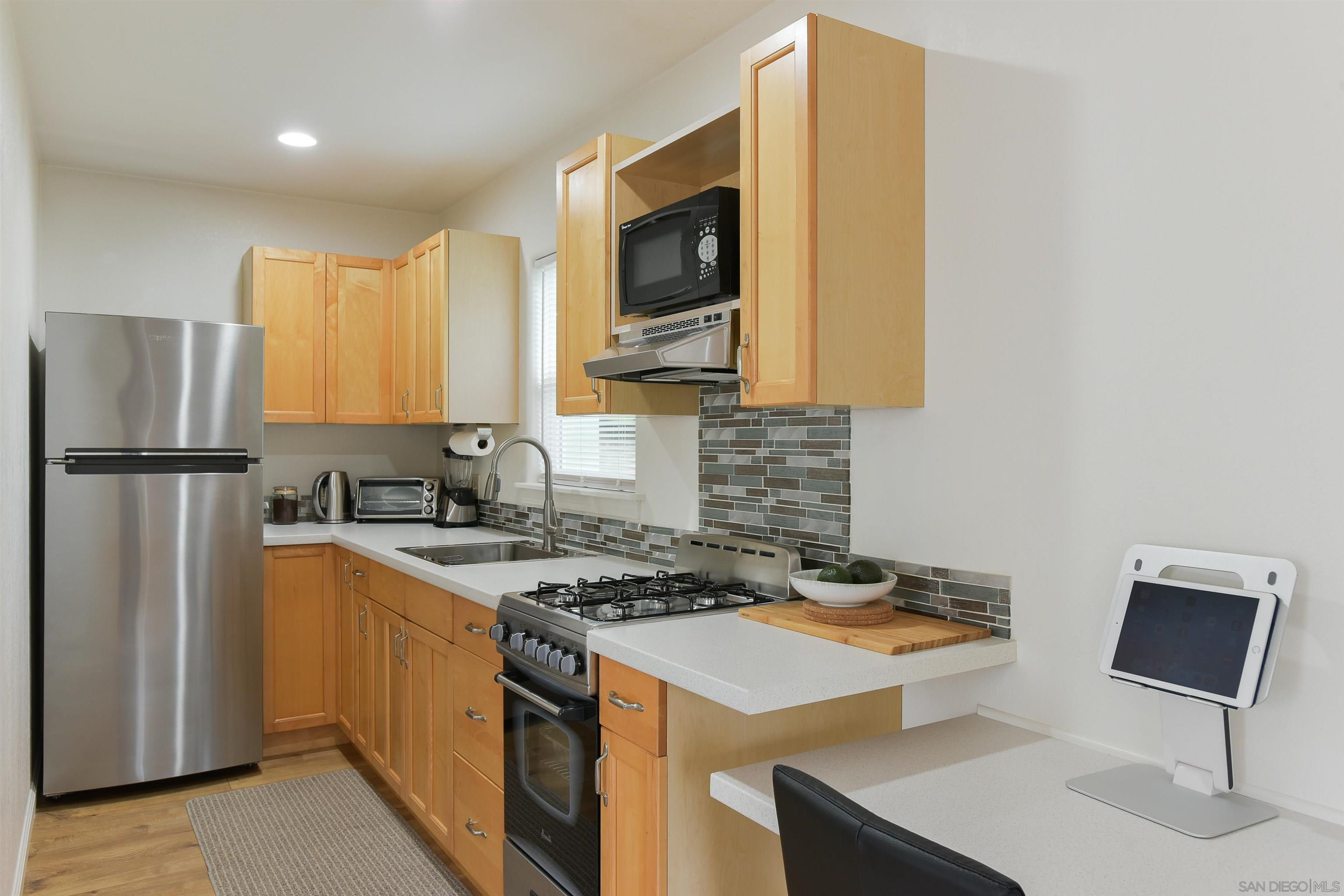 222 Barbara Avenue Solana Beach, CA 92075 - Photo 27 of 37 a kitchen with stainless steel appliances granite countertop a stove refrigerator sink and cabinets