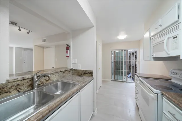 a kitchen with a sink stove and cabinets