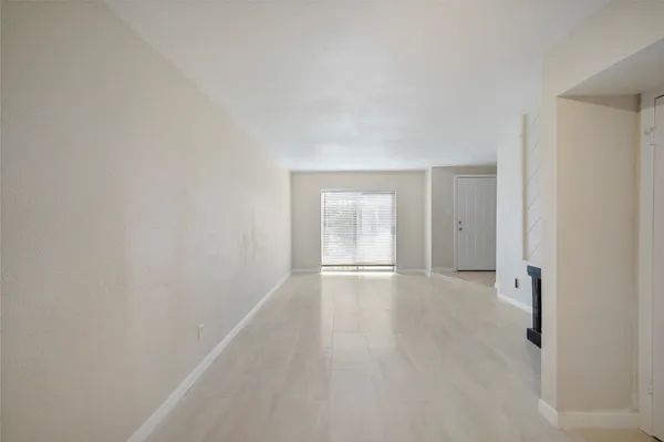 a view of an empty room with wooden floor and closet