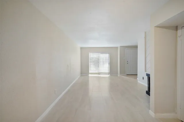 a view of an empty room with wooden floor and closet
