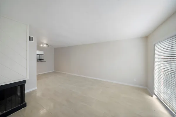 a view of an empty room with a fireplace and a window