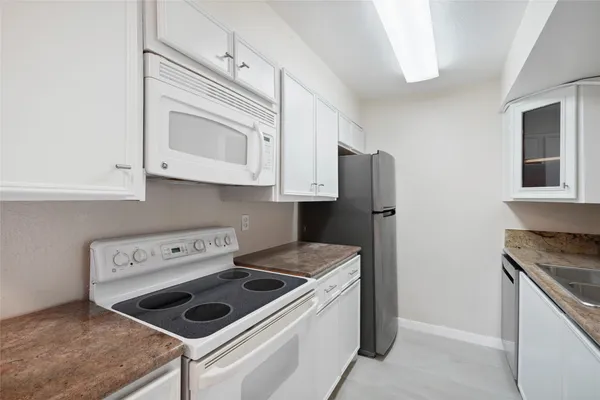 a kitchen with appliances cabinets and a counter top space