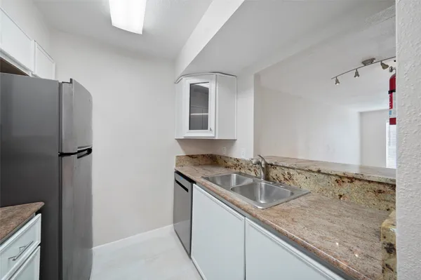 a kitchen with a sink refrigerator and cabinets
