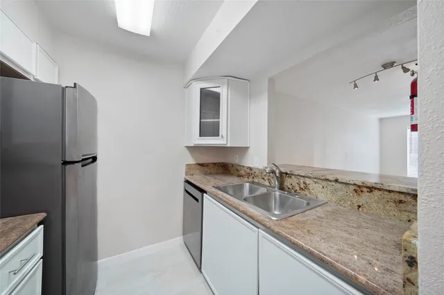 a kitchen with a sink refrigerator and cabinets
