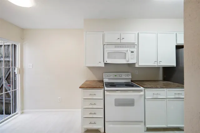 a kitchen with white cabinets and white appliances