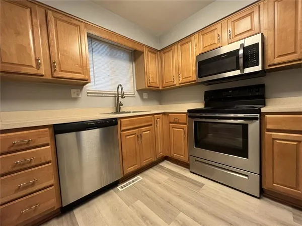 a kitchen with granite countertop cabinets stainless steel appliances and wooden cabinets