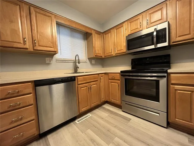 a kitchen with granite countertop cabinets stainless steel appliances and wooden cabinets