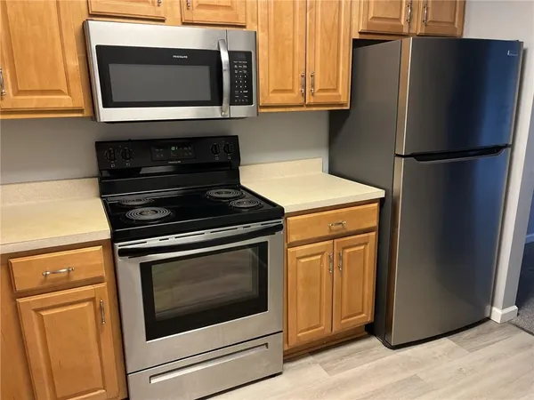 a kitchen with stainless steel appliances white cabinets a stove and a microwave