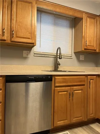 a close view of a sink and a cabinet with wooden floor