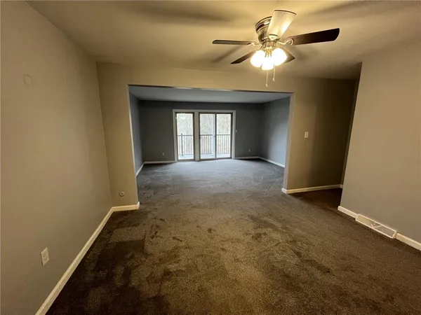 a view of a livingroom with a chandelier fan and a window